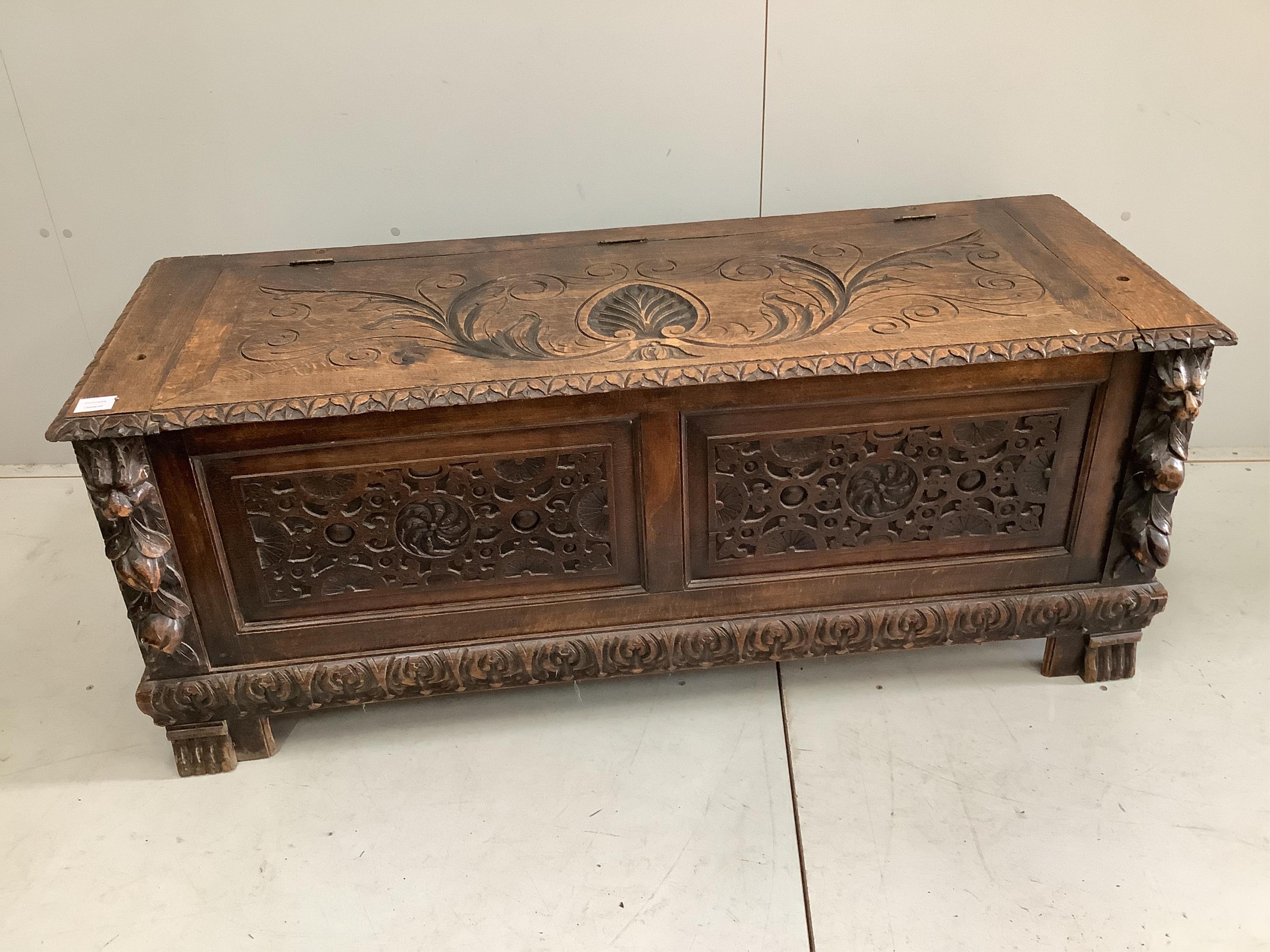 An early 20th century carved oak coffer formerly a monk's bench, width 137cm. Condition - lacking original arms and back, otherwise fair